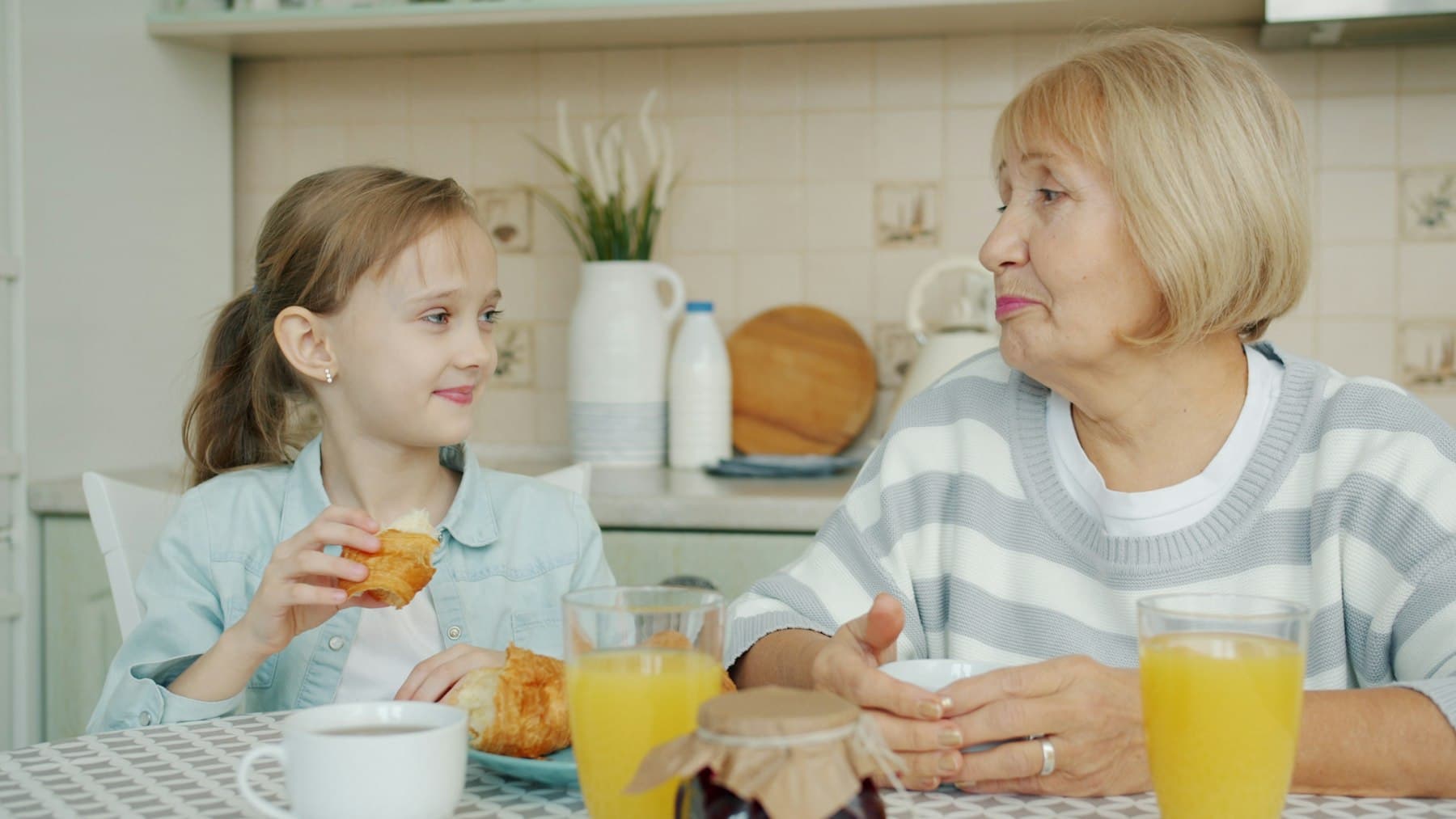 A grandmother and her granddaughter talking at the breakfast table